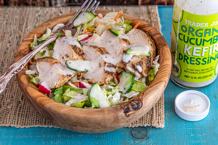 Wood bowl filled with chopped salad and grilled chicken, topped with Trader Joe's Organic Cucumber Kefir Dressing
